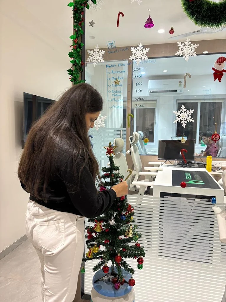 A Beacon Minds team member decorating a Christmas tree in the office